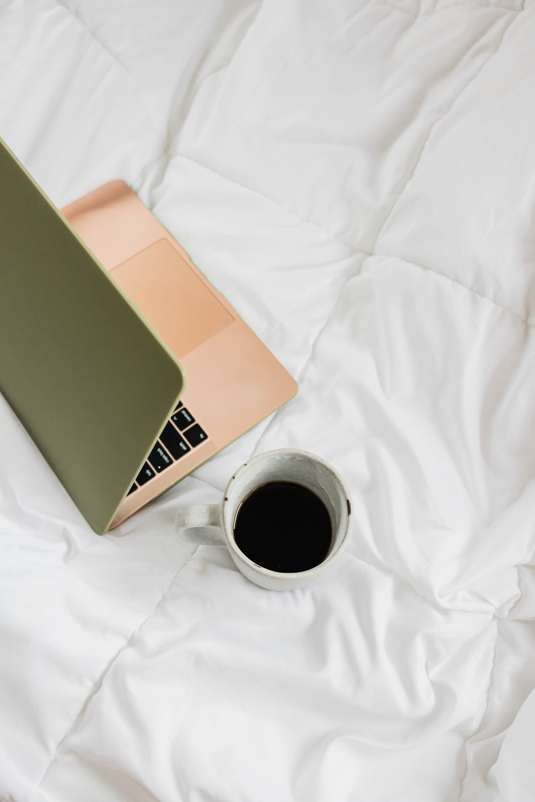 Laptop and Cup of Coffee on Bed
